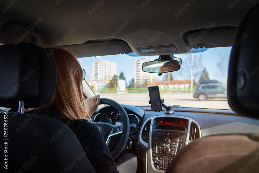 Fototapeta premium Young woman driving inside car on crossway with navigation. Transportation, road on vacation concept