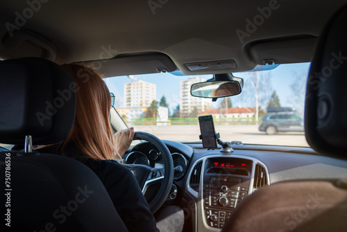 Young woman driving inside car on crossway with navigation. Transportation, road on vacation concept