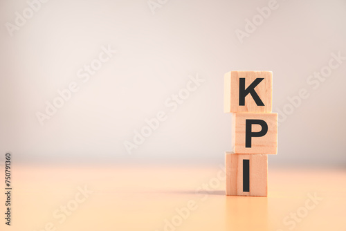 KPI concept. Key Performance Indicator using business intelligence metrics to measure achievement versus planned target. "KPI" abbreviation icons on wood blocks.