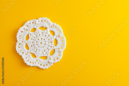White crochet doily on a yellow background with copy space.