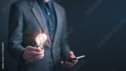 Light bulb holding by  businessman and there is a gear icon in it and ideas of new ideas with innovative technology and creativity. inspiration from idea concept.