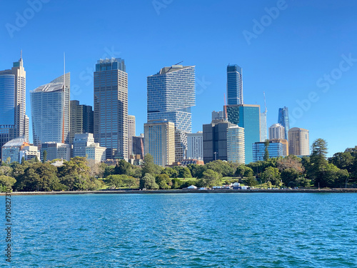 View of Sydney downtown and its iconic buildings and skyscrapers at the distance. Australian city on the horizon. City skyline from the ocean shore. City harbour country, Australia. © Stephanie