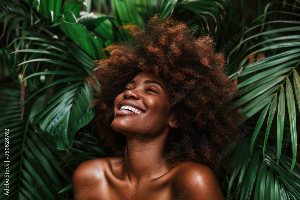 A woman with an afro smiles with joy in front of tall palm trees A woman with an afro smiles with joy in front of tall palm trees