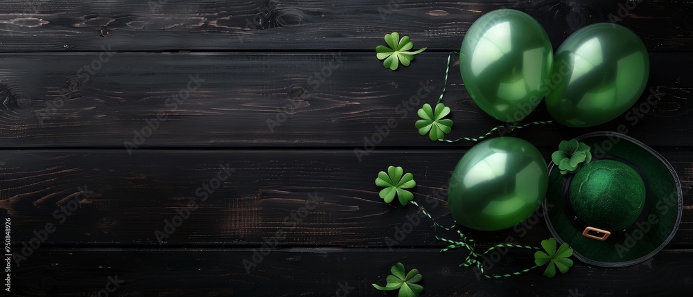 Naklejka premium top view st patricks day four leaf clover, balloons, leprechaun's hat on rustic black wooden table