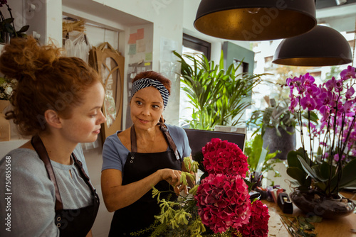 Mother and daughter florists arranging flowers in a flower shop