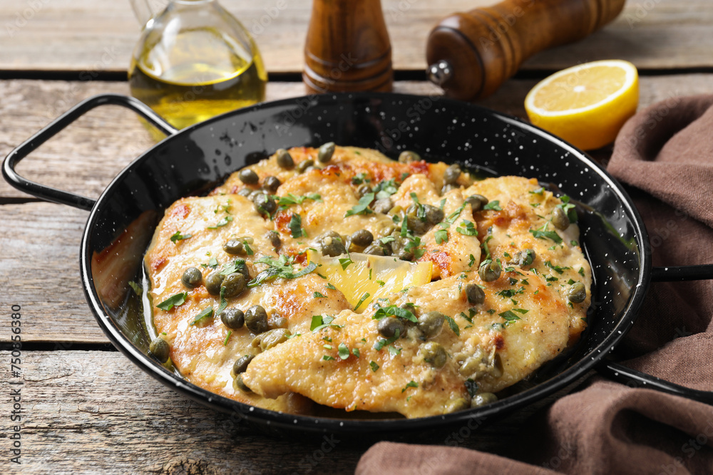 Delicious chicken piccata with herbs on wooden table Delicious chicken piccata with herbs on wooden table