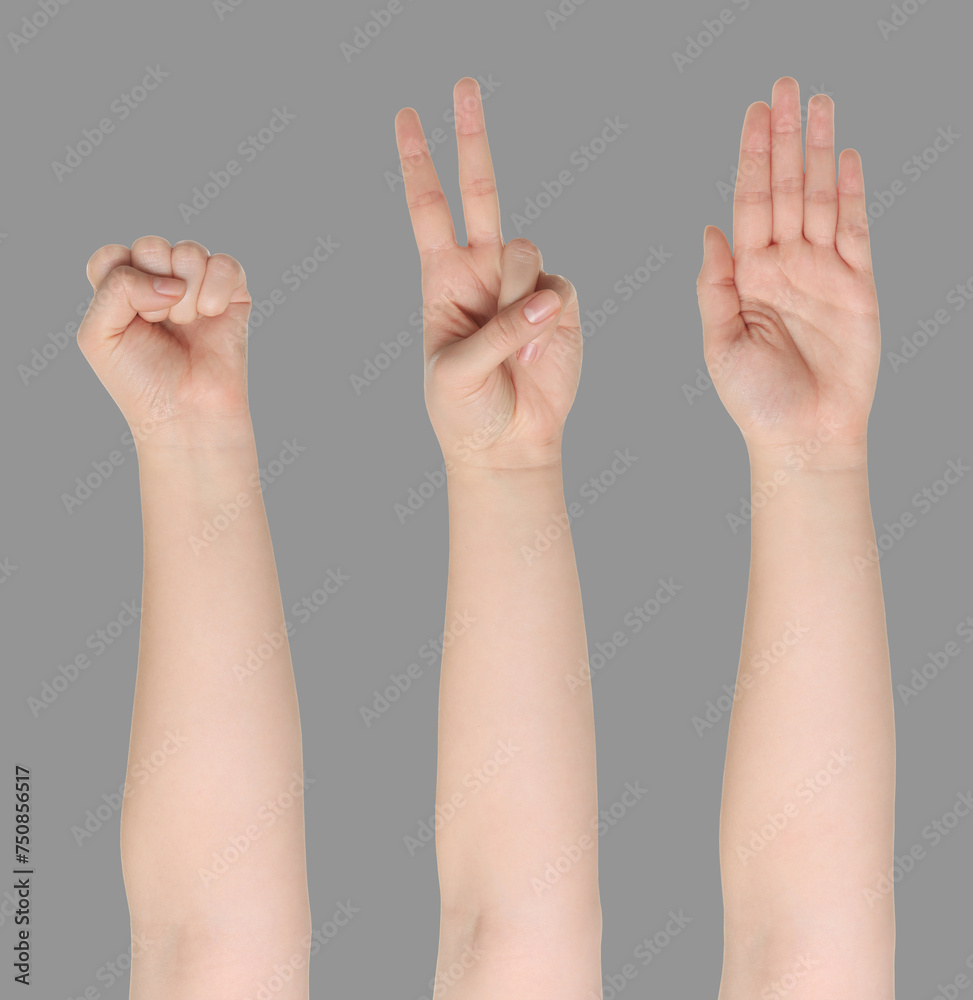 People playing rock, paper and scissors on grey background, closeup People playing rock, paper and scissors on grey background, closeup