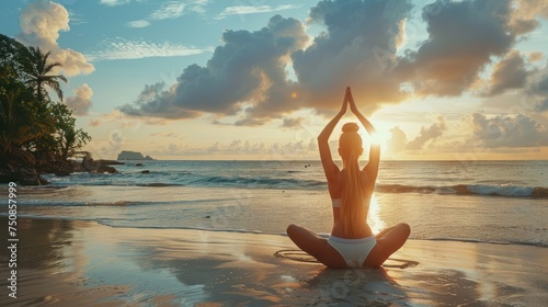 woman practicing yoga on the beach at warm sunset light, back view