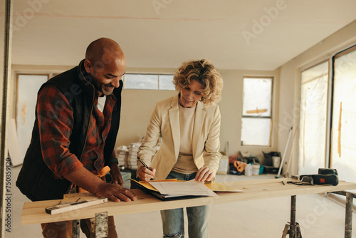 Female homeowner signing a property renovation contract with a professional contractor
