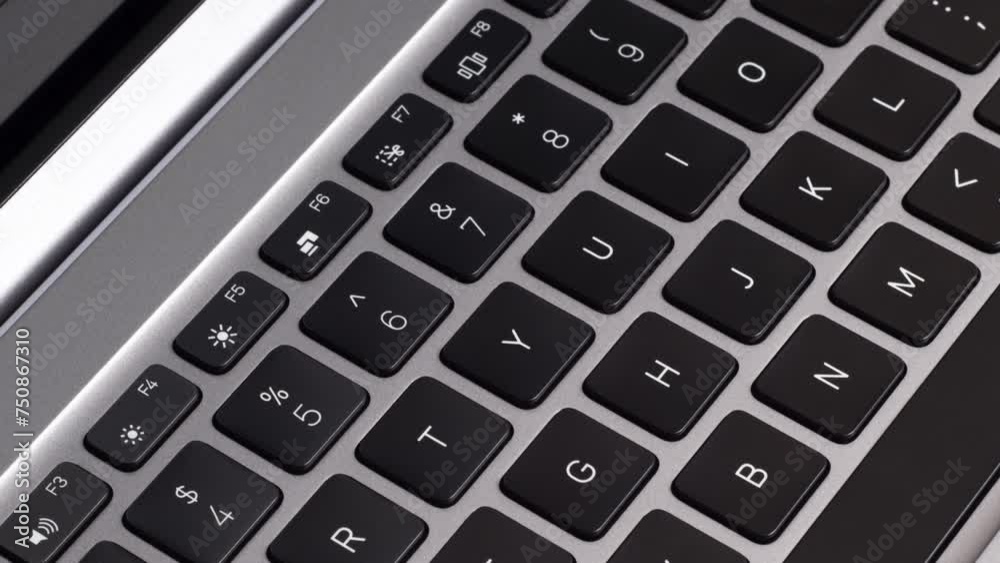 Video close up of new gray laptop keyboard and screen close up. Camera slide on laptop black keyboard with white letters Video close up of new gray laptop keyboard and screen close up. Camera slide on laptop black keyboard with white letters