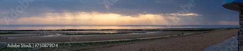 Langrune-Sur-Mer, France - 08 08 2020: View of the sea from the beach at sunset with cloudy sky.