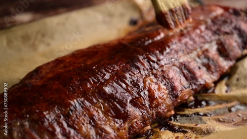 applying bbq sauce on pork spare ribs with brush