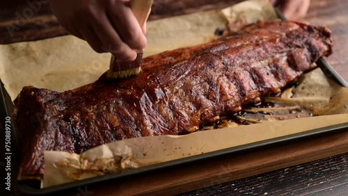 applying bbq sauce on pork spare ribs with brush
