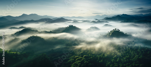 Aerial view of misty mountains and lush forests at sunrise, capturing the ethereal beauty and tranquility of a summer morning in nature.