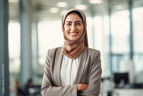 Portrait of smiling beautiful modern Muslim businesswoman in casual business suit and traditional hijab standing in the modern office. Confident Arabian lady. Equal women rights in Eastern countries. photo