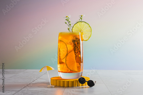 orange summer cocktail on glass with lemon slice and tiny miniture sunglasses and umbrella photo