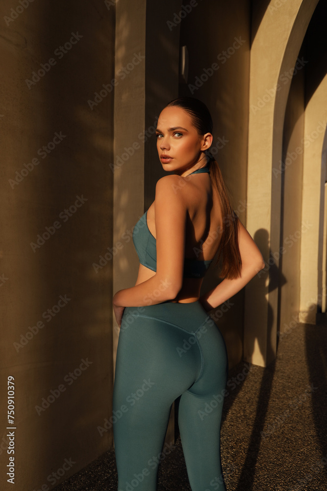 beautiful slavic woman with dark hair in elegant sportive suit posing in the arch