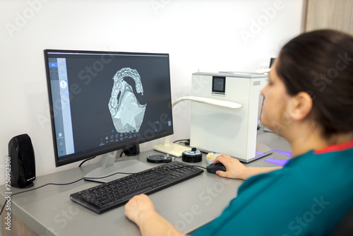 Dentist working on computer with a dental scan software for make dental prosthesis. Dentist working on prostheses