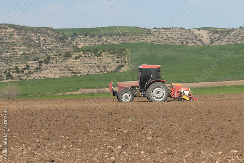 Tractor plowing fields to plant sunflowers photo