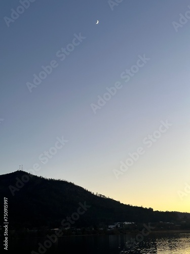 Crescent moon over the mountains and Minho river after the sunset, Eiras, O Rosal, Galicia, Spain, December 2022 photo