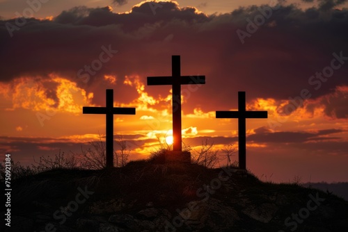 Three crosses on a hill with dramatic sunset in the background