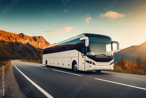 White intercity bus cruising on highway with mountainous backdrop at sunset.