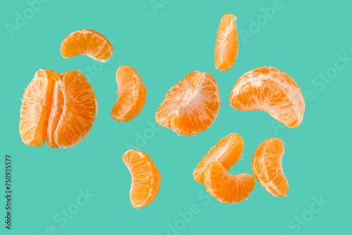 Flying pieces of sweet peeled mandarin on turquoise background