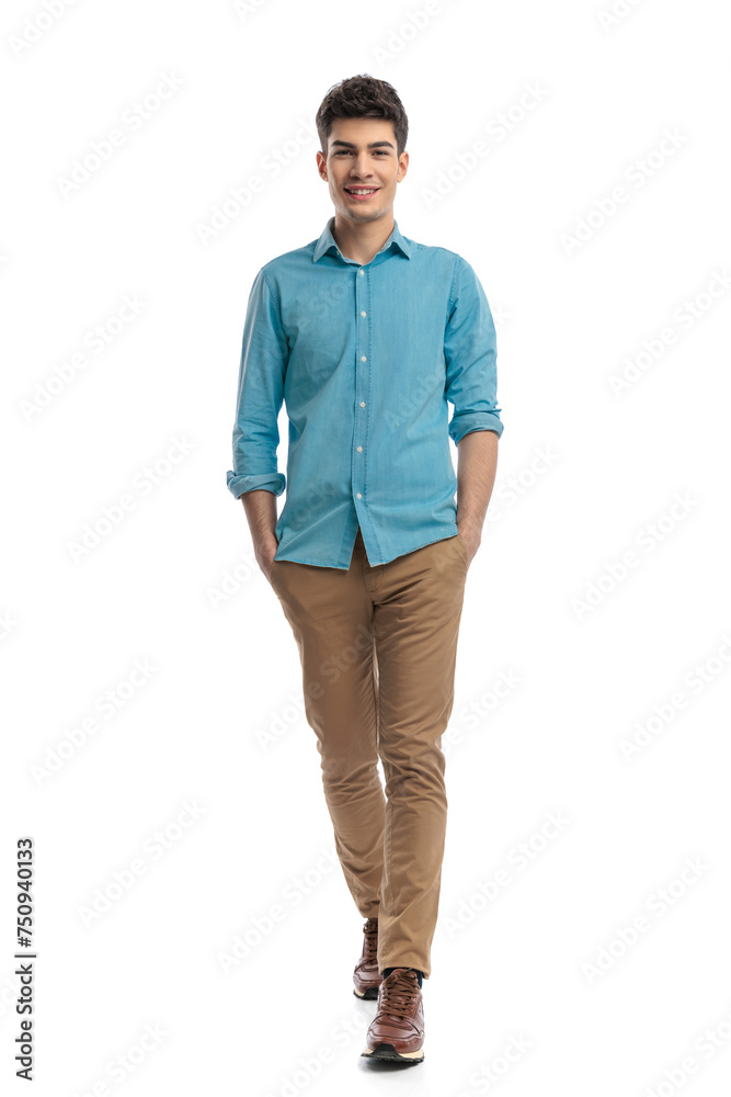 Fototapeta premium attractive young man with hands in pockets moving forward