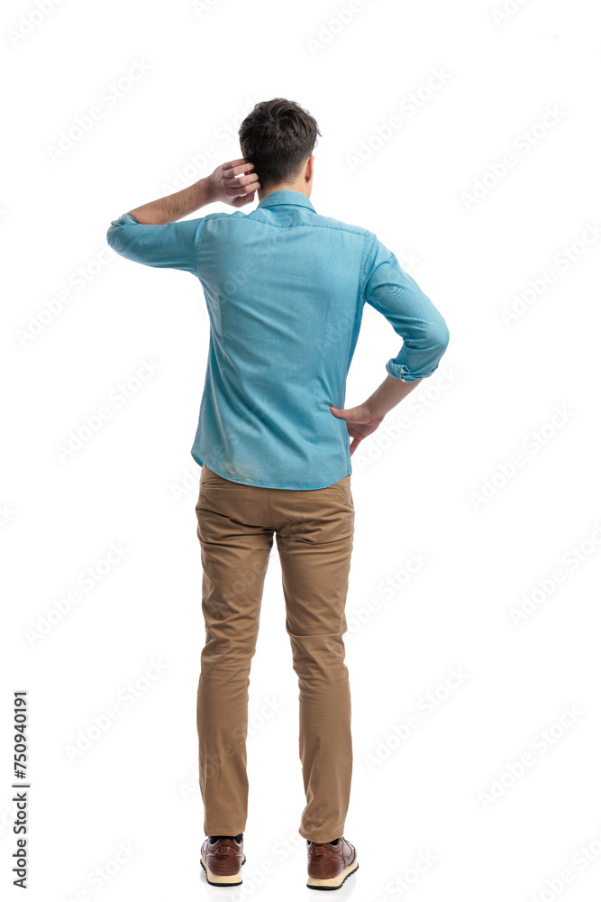 back view of puzzled casual man scratching his head
