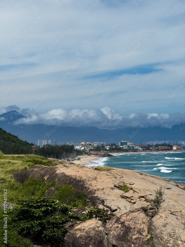 Macumba Beach and Recreio dos Bandeirantes in Rio de Janeiro, Brazil. Pedra do Pontal and Pedra da Gávea in the background. Beach on the west side of town. Sunny day and people on the beach