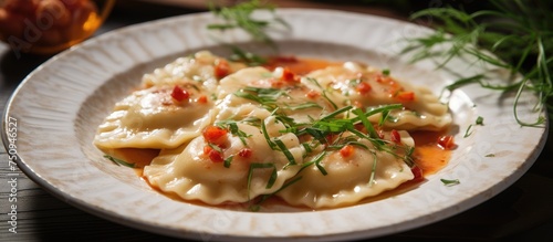 A white plate is shown topped with homemade ravioli covered in a rich, savory sauce, creating a mouthwatering and appetizing meal. The dish is visually appealing and ready to be enjoyed.