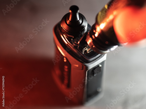 Refill with e-juice or liquid with salt nicotine on vape pod. Close-up, refillable vape cartridge