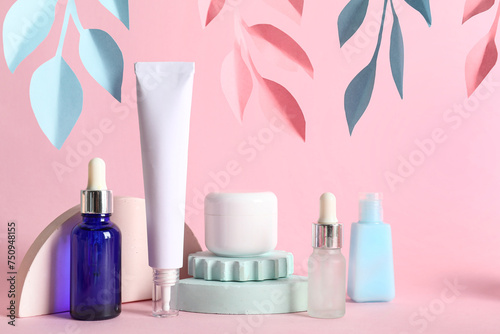 Facial cosmetic products composition with paper flowers on pink background