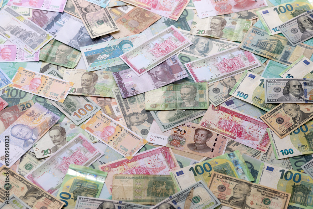 Many banknotes of different currency. Background of big amount of random money bills close up Many banknotes of different currency. Background of big amount of random money bills close up