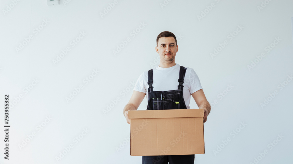 Professional delivery guy employee man wear white t-shirt and black uniform workwear work as dealer courier hold cardboard box. Service concept Professional delivery guy employee man wear white t-shirt and black uniform workwear work as dealer courier hold cardboard box. Service concept