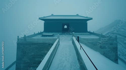 a snow covered walkway leading to a building on top of a mountain with a gate in the middle of it.