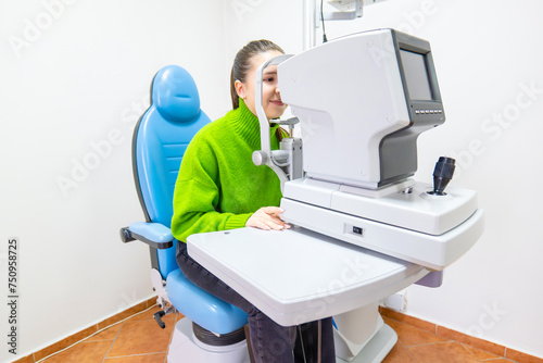 a woman is sitting in a chair getting her eyes checked by an ophthalmologist photo