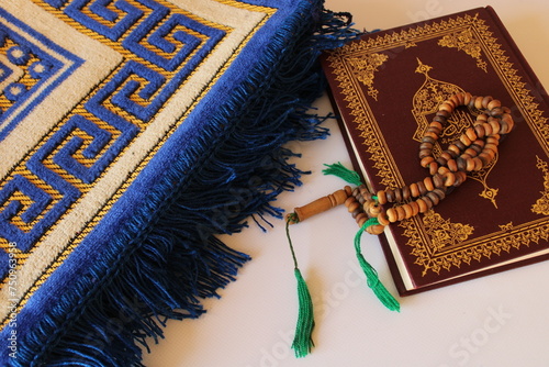 Holy quran and prayer rosary on prayer mat on white background. Islamic concept. ramadan kareem