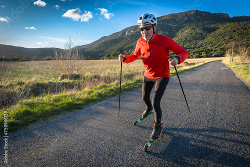un homme âgé sur des ski-roues en plaine campagne  sur une route goudronnée