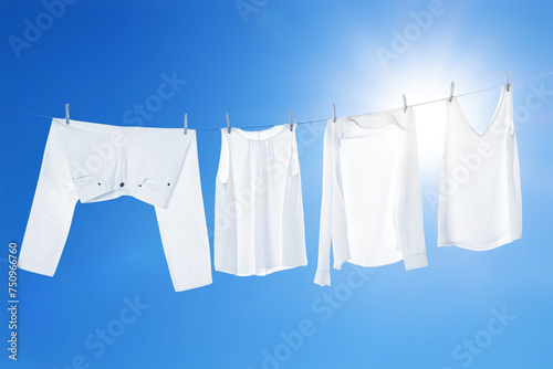 Different clothes drying on washing line against blue sky © New Africa