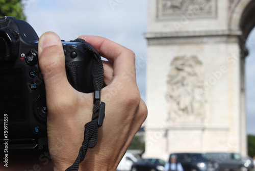 Photographer's hands with a camera near the Triumphal Arch, Arc de Triomph, Paris, France photo