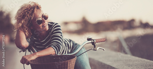 One cute woman smile and enjoy outdoor leisure activity alone having relax on her bike. Happy female people smile and look wearing sunglasses. Healthy transport lifestyle people sustainability