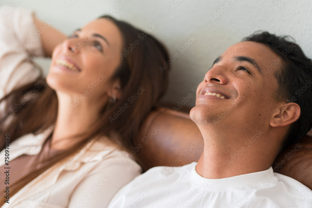 Happy young couple dreaming together looking up at home their future. Couple dream future. Young beautiful loving couple relaxing on sofa together, happy millennial family sitting on couch on cozy Happy young couple dreaming together looking up at home their future. Couple dream future. Young beautiful loving couple relaxing on sofa together, happy millennial family sitting on couch on cozy