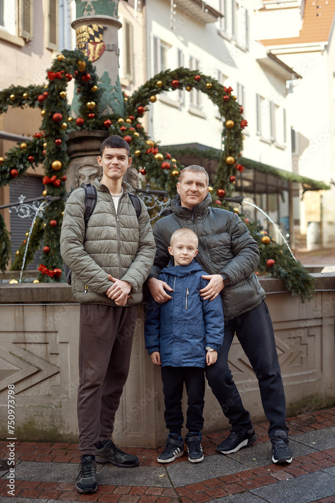 Joyful Family Portrait: Father and Two Sons by Festive Vintage Fountain.