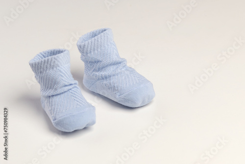 baby socks, for newborns, the first shoes with delicate feet on a light background