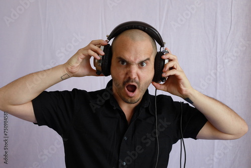 baldman wearing headphones , music listening and funny expressions photo