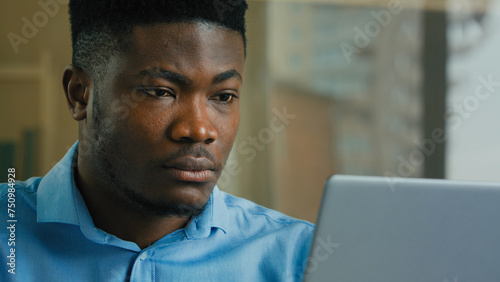 African American business man employee professional manager working on laptop computer from home office male ethnic executive studying browsing web focused businessman analyzing digital data online