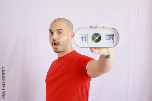 expressive bald man holding and showing the analog clock
