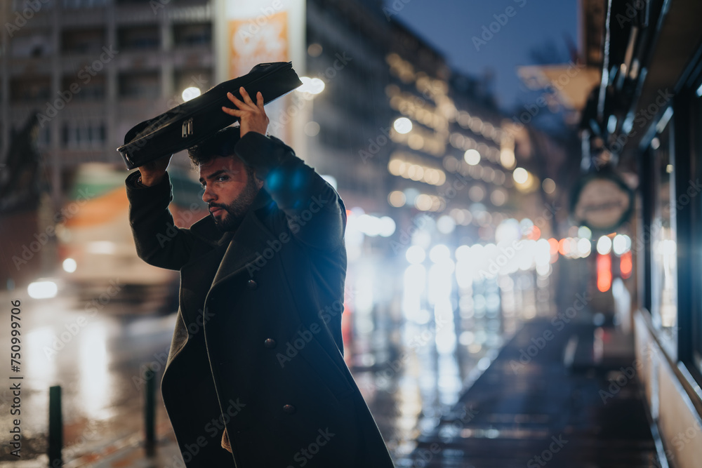 Obraz premium Busy businessman waiting for a cab in the rainy city night.
