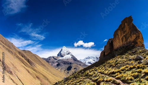 a triangular rock in a vally under a deep blue sky in the andes photo